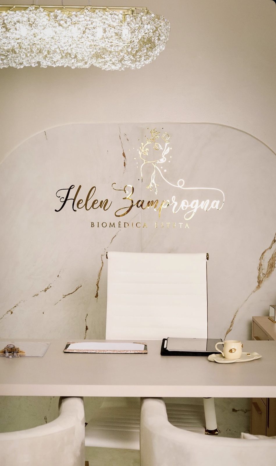 Consultório da Dra. Helen com o logo dourado na parede de mármore